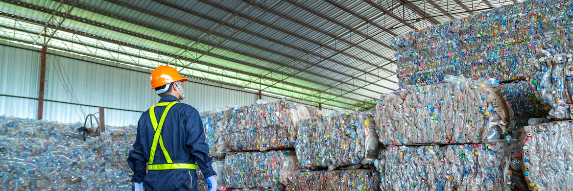 Workers In Landfill Dumping, Garbage Engineer, Recycling, Wearing A Safety Suit Standing In The Recycling Center Have A Plastic Bottle For Recycling In The Factory.